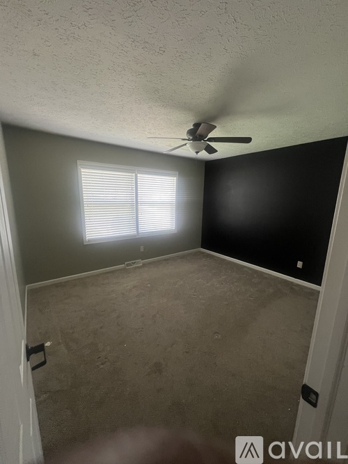 A room with a ceiling fan and a window.
