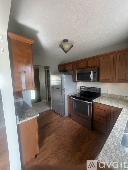 A kitchen with wooden cabinets and a granite counter top.