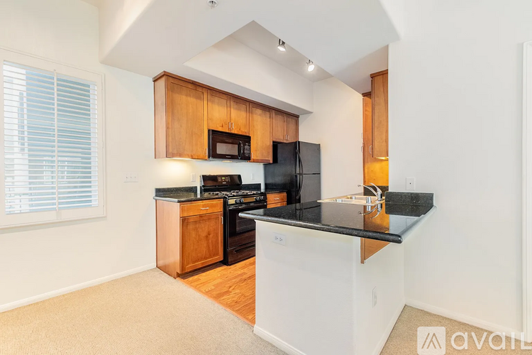 A kitchen with wooden cabinets and black countertops.