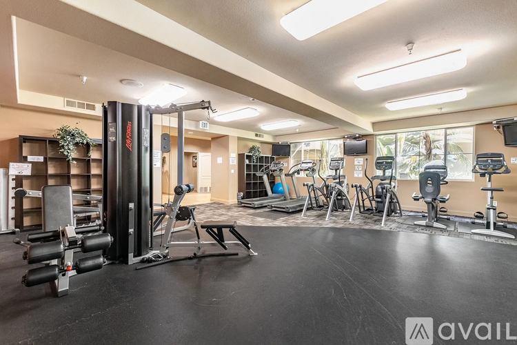 A gym with a variety of equipment including treadmills, weights, and exercise machines.