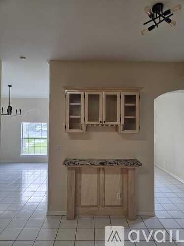 A kitchen with a marble countertop and wooden cabinets.