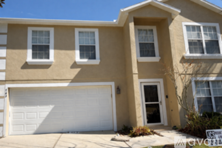 A beige house with a white garage door.