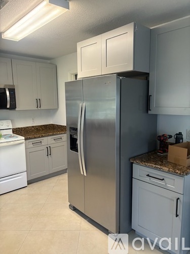 A kitchen with a stainless steel refrigerator and white appliances.