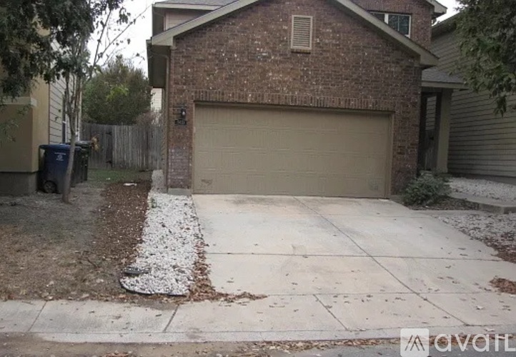 A brick house with a garage door and a driveway.
