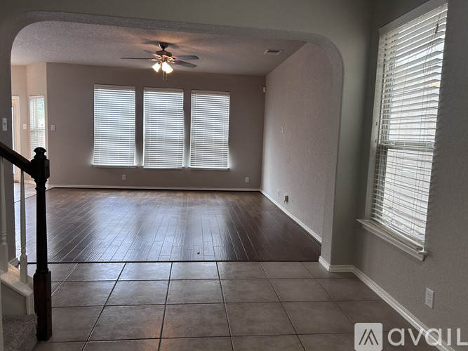 A room with a ceiling fan and tiled flooring.