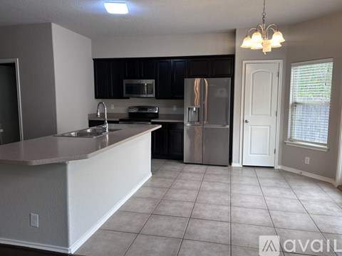 A kitchen with a white counter and black cabinets.
