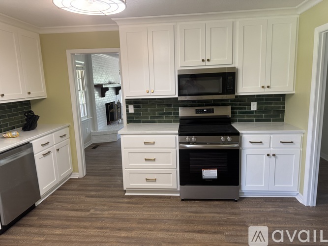 A kitchen with white cabinets and a black oven.