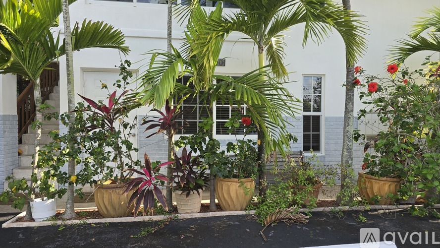 A white house with a garden in front.