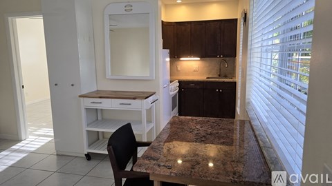 A kitchen with a granite countertop and a white cabinet.