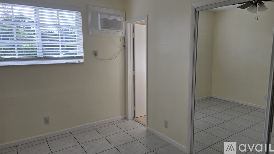 A room with a window, a door, and a fan.