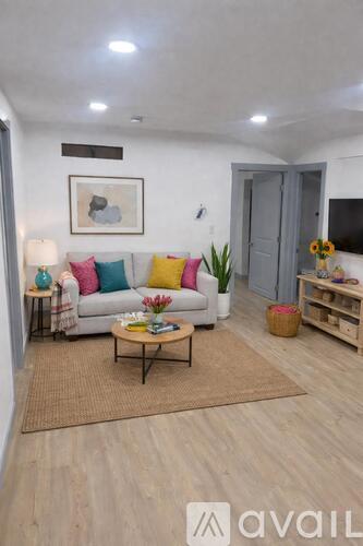 A living room with a white couch, a coffee table, and a grey door.