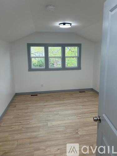 A room with a window and wooden flooring.