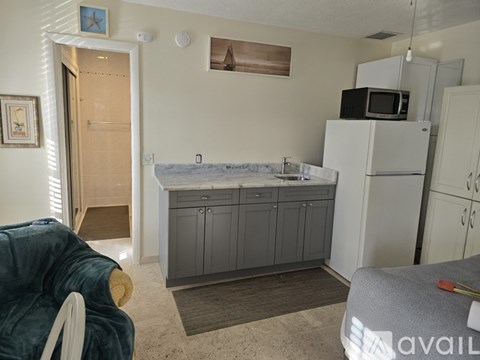 A kitchen area with a sink, microwave, and cabinets.