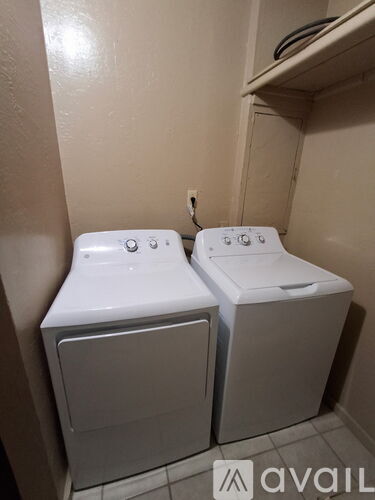 Two white washing machines in a small room.