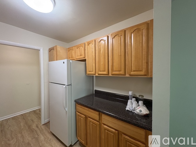 A kitchen with wooden cabinets and a white refrigerator.