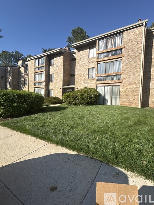 A building with a lawn in front and a sign that says "available".