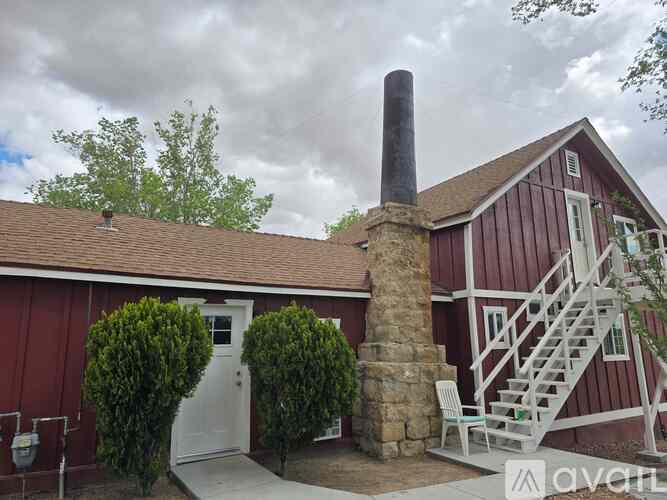 A red barn with a white door and a stone chimney.