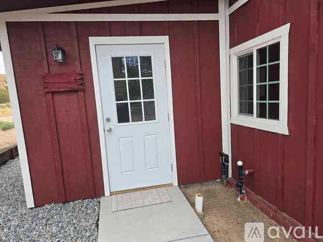 A red building with a white door and a window.
