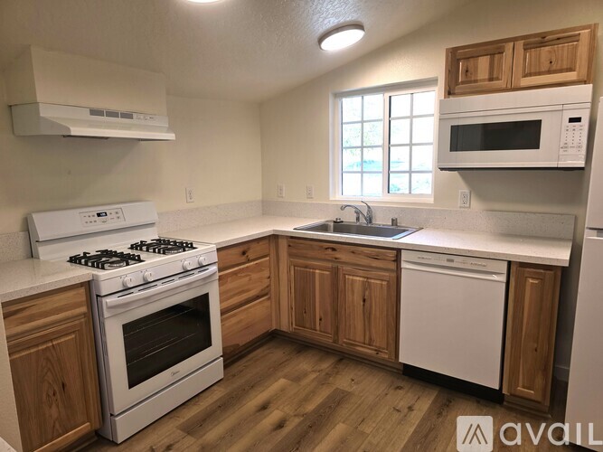 A kitchen with wooden cabinets and white appliances.