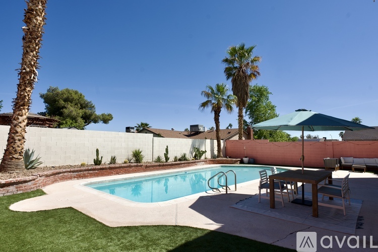 A pool surrounded by a patio and palm trees.