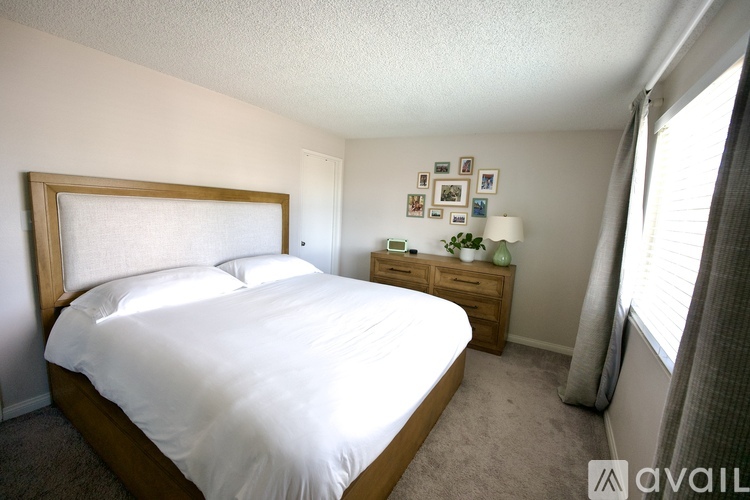 A bedroom with a large bed and a nightstand with a lamp.