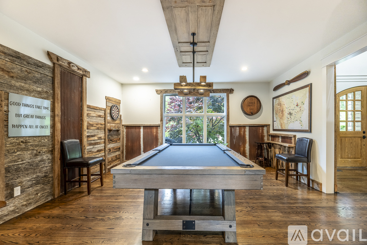 A pool table in the middle of a room with wooden floors and walls.
