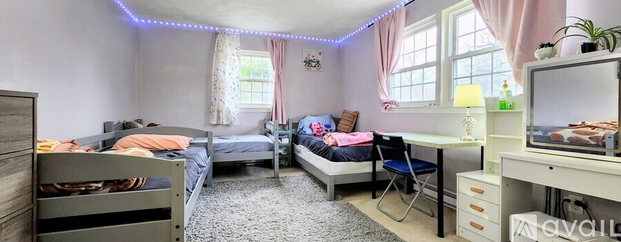 A bedroom with bunk beds and a desk with a TV on top.