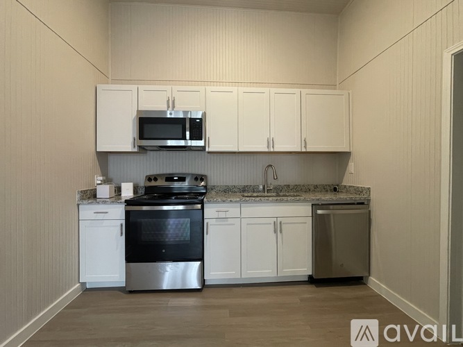 A kitchen with white cabinets and a granite countertop.
