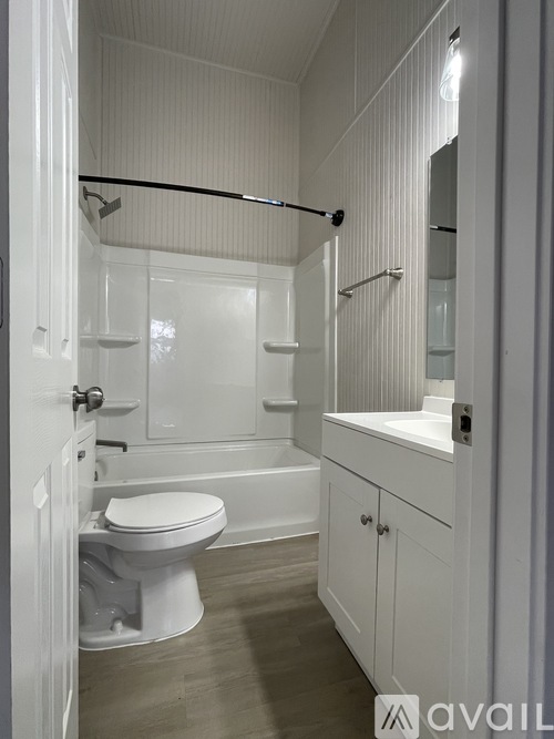 A white bathroom with a toilet, sink, and bathtub.