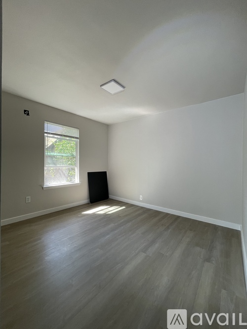 A room with a window and a speaker on the floor.