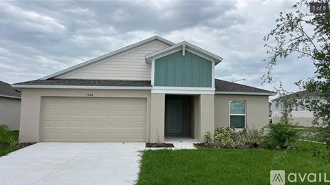 A house with a garage door and a driveway in front.