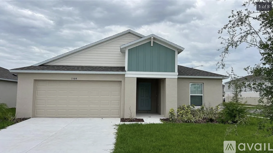A house with a garage door and a driveway in front.