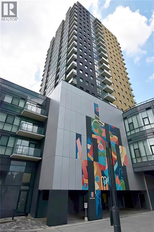 A tall building with a mural on the side of a low building.