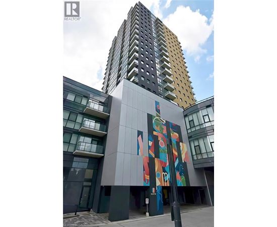 A tall building with a mural on the side of a low building.