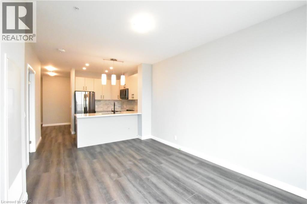 A spacious room with wooden flooring and white walls.
