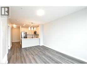 A spacious room with wooden flooring and white walls.