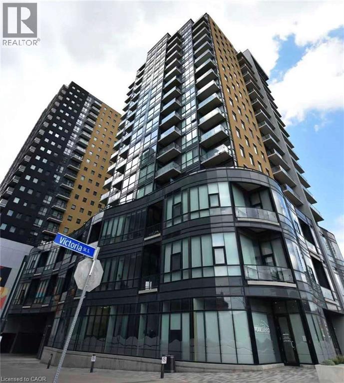 A tall building with a curved design and a sign that says Victoria St.