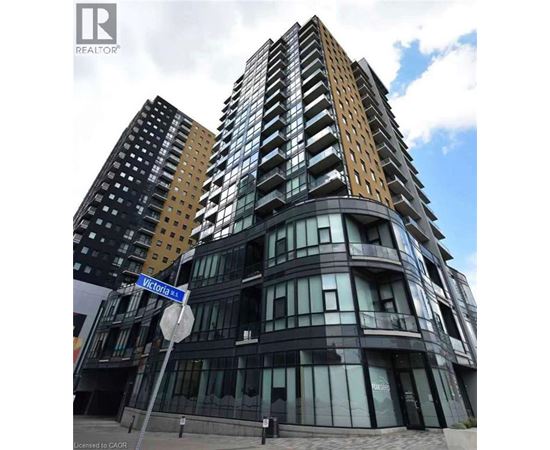 A tall building with a curved design and a sign that says Victoria St.