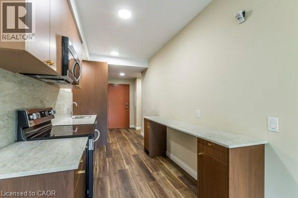 A well-lit kitchen with wooden floors and modern appliances.