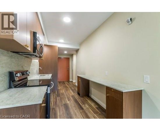 A well-lit kitchen with wooden floors and modern appliances.