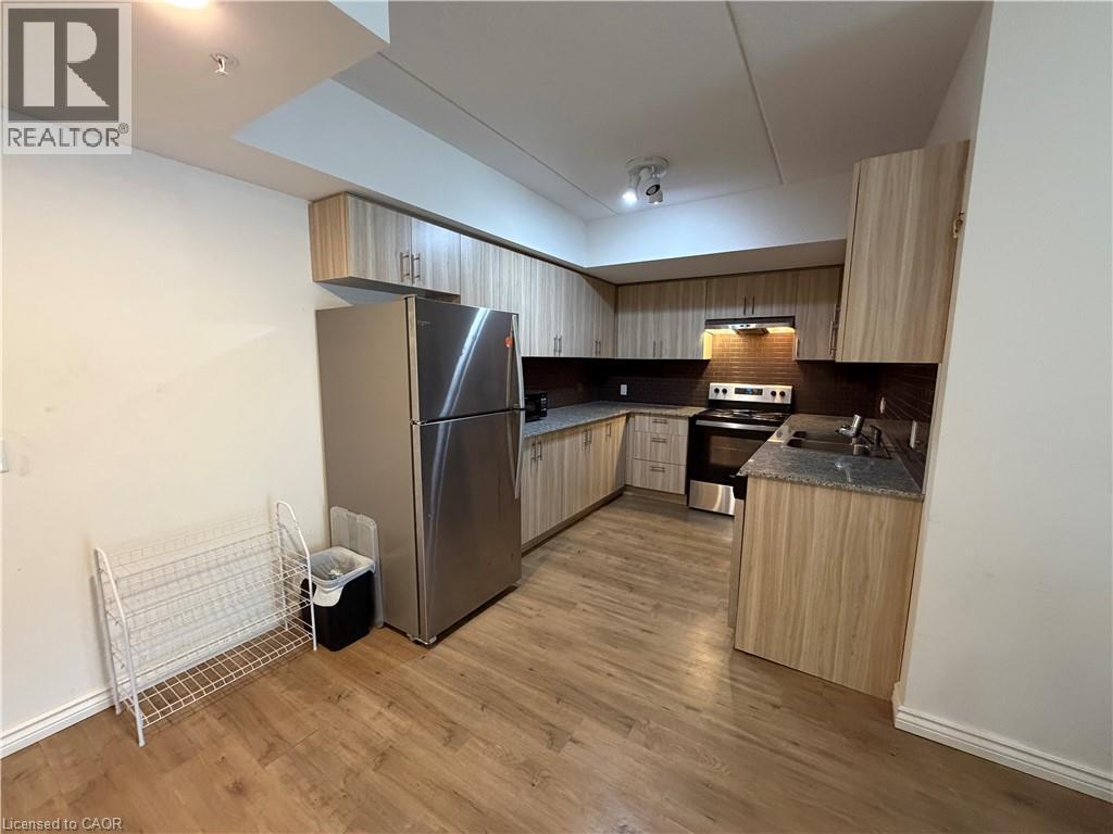 A kitchen with wooden cabinets and a stainless steel refrigerator.