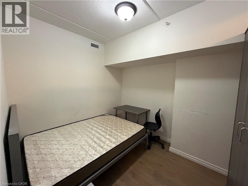 A bedroom with a bed, desk, and chair.