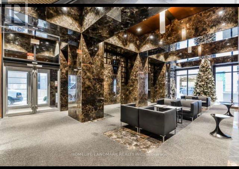 A lobby with a marble floor and walls, a Christmas tree, and a reception desk.