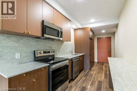 A kitchen with wooden cabinets and a marble countertop.