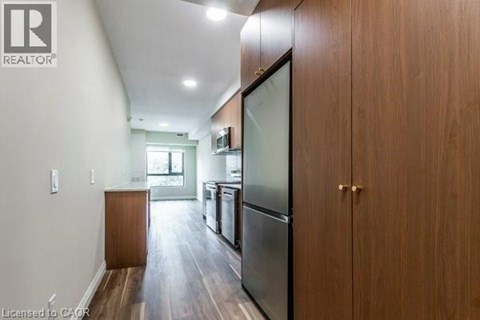 A kitchen with wooden cabinets and a refrigerator.