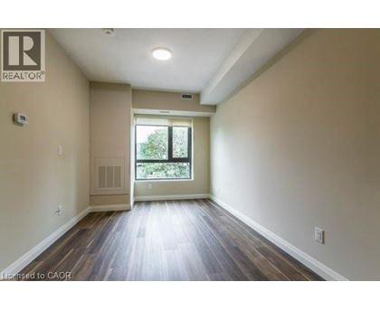 A spacious room with wooden floors and a large window.