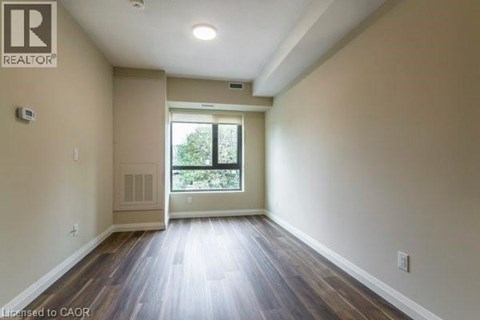 A spacious room with wooden floors and a large window.