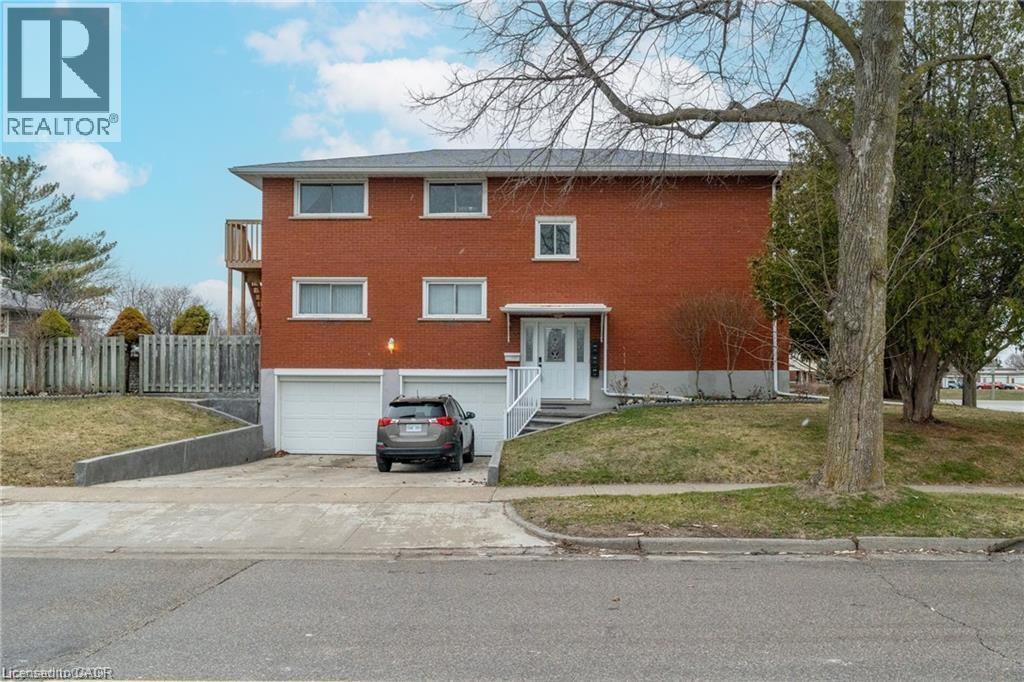 A red brick house with a car parked in front.