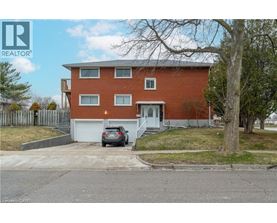 A red brick house with a car parked in front.