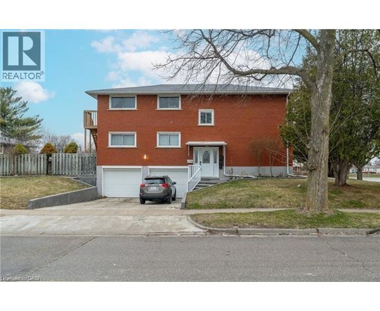 A red brick house with a car parked in front.
